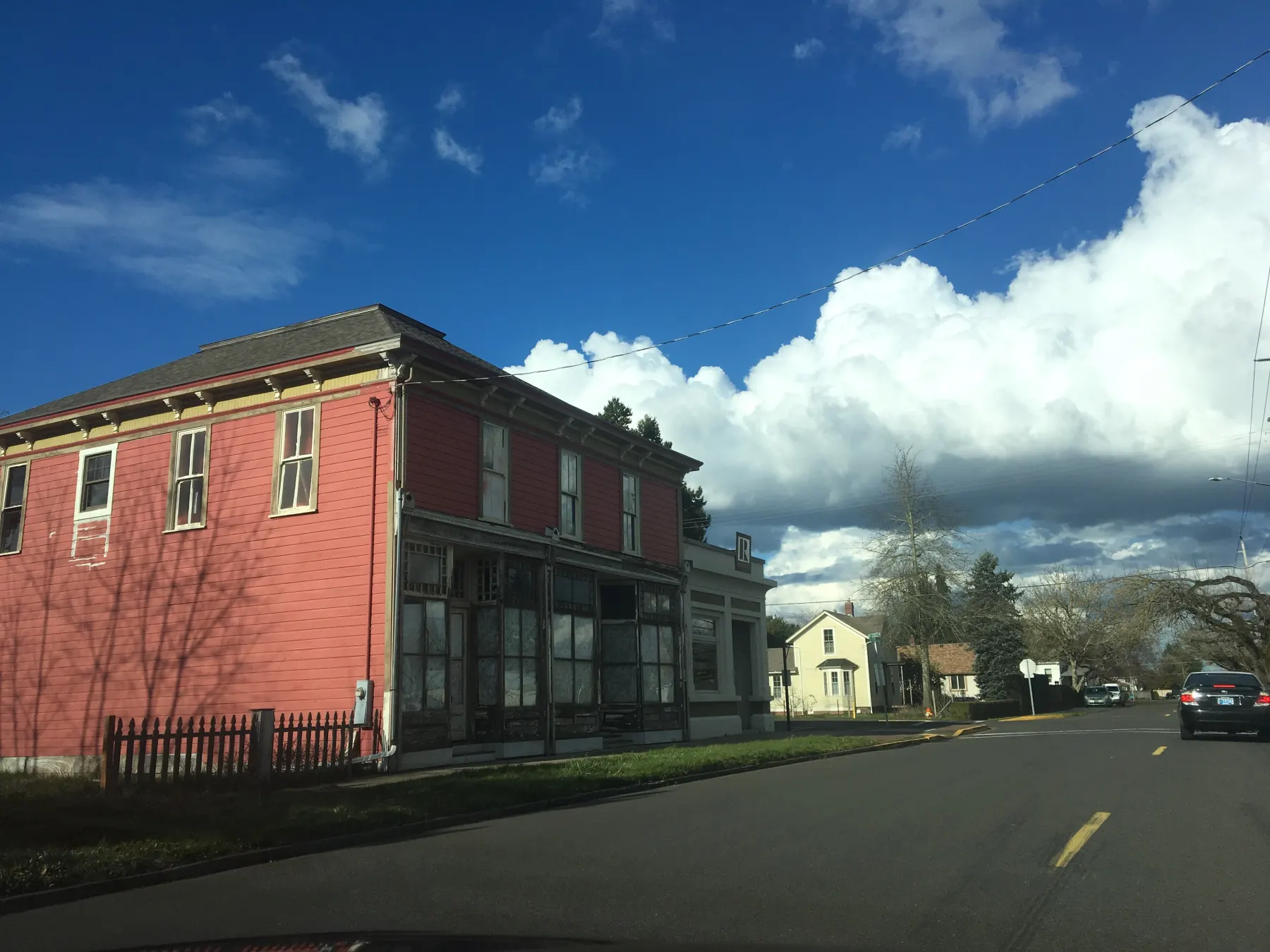A red timber commercial building on the main road through Hubbard, Oregon, under building cloud